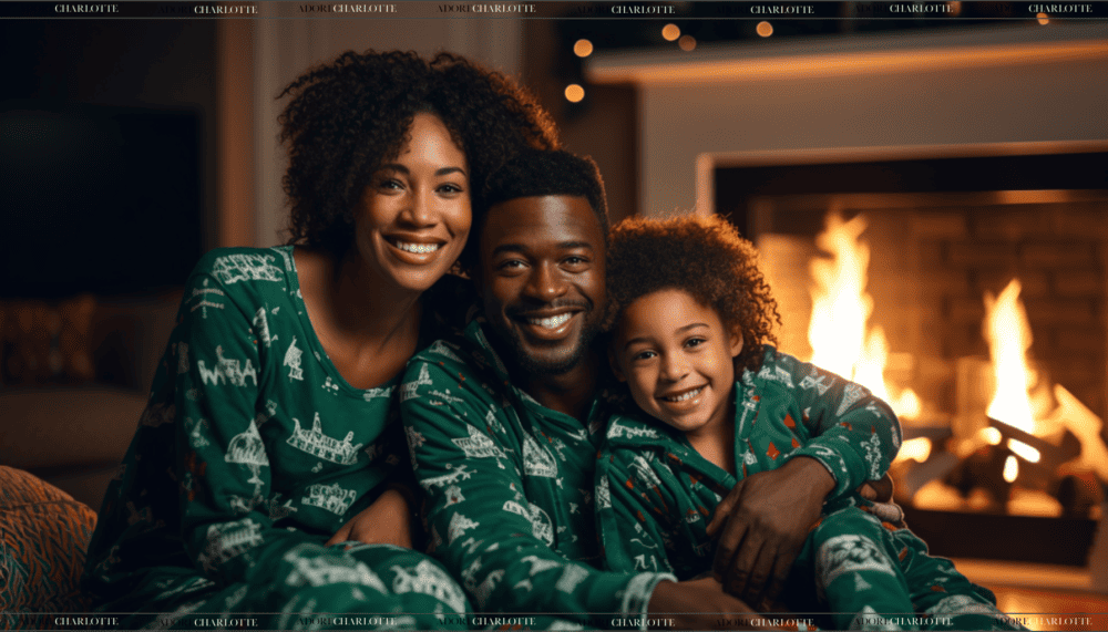 A beautiful black family wearing matching Christmas pyjamas as part of their Christmas Eve Traditions. They are sitting in a cozy living room with a fireplace, Christmas tree, and festive decorations, smiling and enjoying a warm, festive atmosphere.
