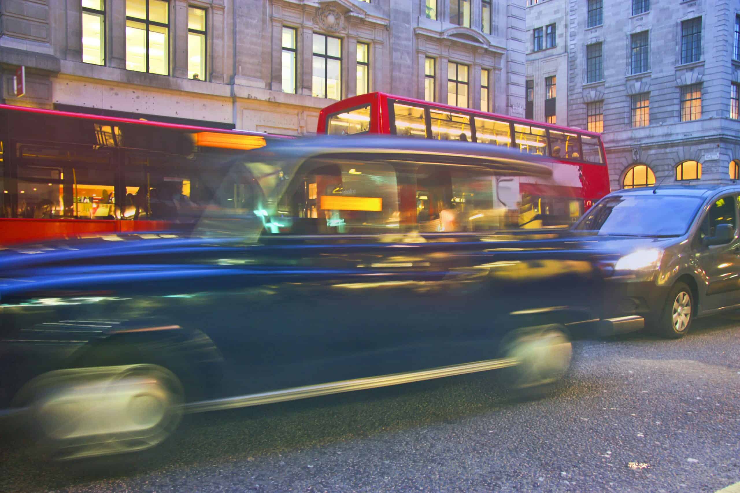 Busy streets of London, Black Taxi and. Red London Bus driving on a London Road.