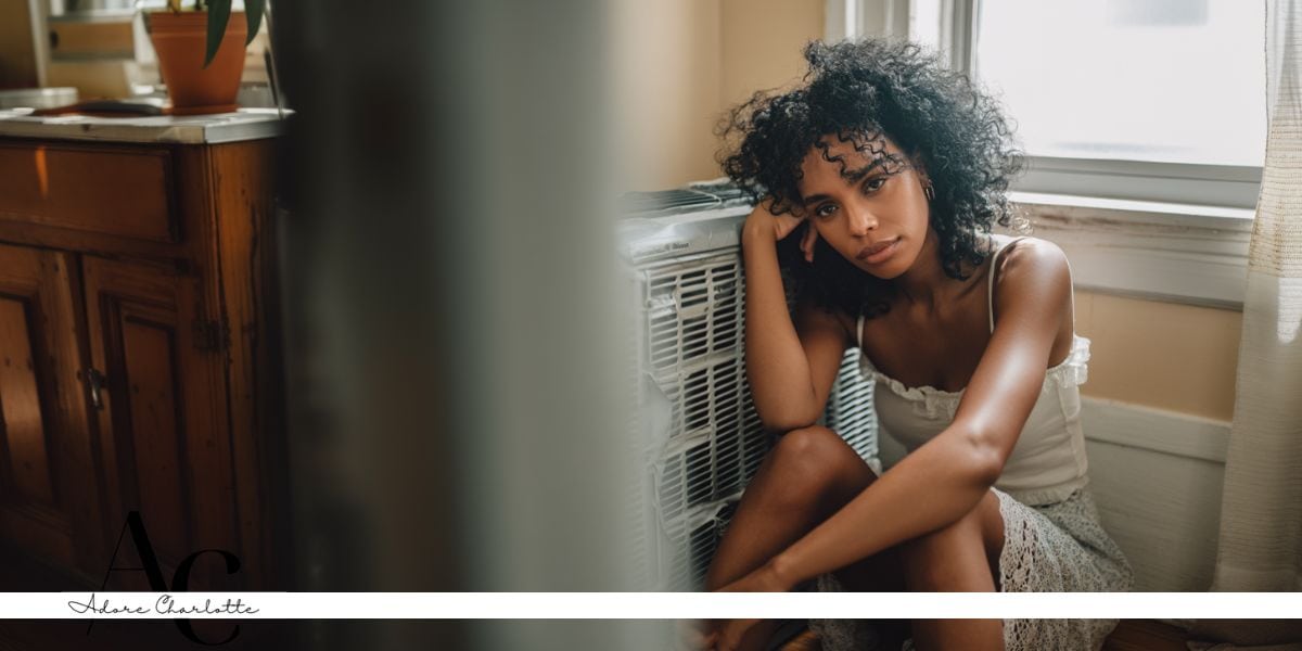 Air Conditioning System Faults woman sitting next to a broken unit.