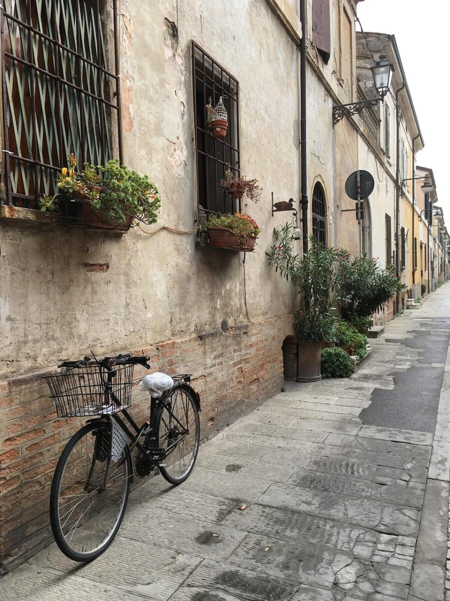 A bike resting on a wall on a street in Italy